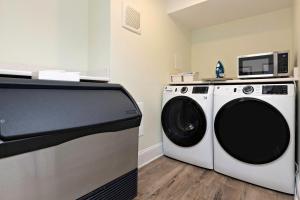 uma lavandaria com uma máquina de lavar roupa e um micro-ondas em Pinewood 102 Inn At Old Beach em Virginia Beach