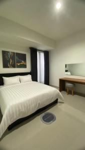 1 dormitorio con 1 cama blanca grande y escritorio en i Two Panorama Villas en Batu