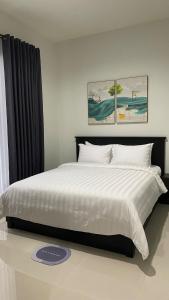 1 dormitorio con 1 cama grande con sábanas y almohadas blancas en i Two Panorama Villas en Batu