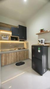 Una cocina con refrigerador negro y gabinetes de madera. en i Two Panorama Villas, en Batu