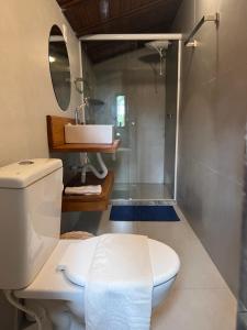 uma casa de banho com um WC, um lavatório e um chuveiro em Casa do João na Ilha de Boipeba