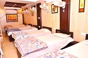 four beds lined up in a row in a room at Goroomgo Comfort Hostel Charbagh Lucknow Near Railway Station in Lucknow