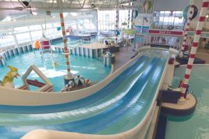 a large indoor swimming pool with a water slide at MemoryMakersHoliday Buena Vista in Chwilog
