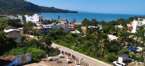 a town on a hill with the ocean in the background at HOTEL PARAISO ESCONDIDO in Chacala