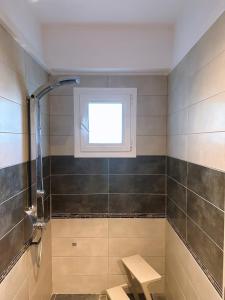 a bathroom with a window and a bench in it at Stylish & Cozy Studio in Igoumenitsa