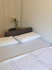 two beds in a room with a vase of flowers at Stylish & Cozy Studio in Igoumenitsa