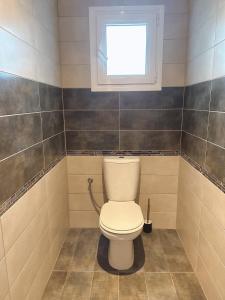 a bathroom with a toilet with a window at Stylish & Cozy Studio in Igoumenitsa +1 photo