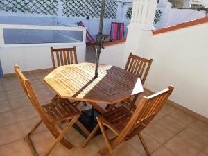 tavolo da pranzo con sedie e ombrellone di Casa da Madalena a Faro