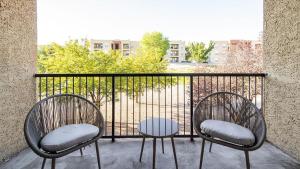 2 sillas y una mesa en el balcón en Landing Modern Apartment with Amazing Amenities (ID6628X19), en Albuquerque