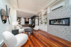 a living room with white furniture and a tv at -NEW- The Rock and Red Luxury Condo in Quebec City