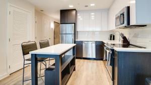 a kitchen with a blue table and chairs in it at Landing Modern Apartment with Amazing Amenities (ID7709X66) in Baltimore