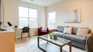 een woonkamer met een bank en een tafel bij Landing Modern Apartment with Amazing Amenities (ID7221X88) in Frederick