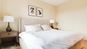 Landing Modern Apartment with Amazing Amenities (ID7221X88) في فريدريك: غرفة نوم بسرير ابيض كبير ومصباحين