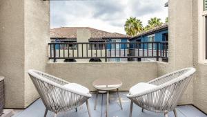 d'une terrasse avec 2 chaises et une table sur un balcon. dans l'établissement Landing Modern Apartment with Amazing Amenities (ID7594X27), à San Diego