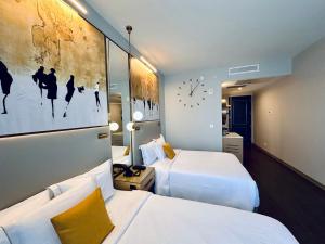 una habitación de hotel con 2 camas y un cuadro en la pared en Chez Hotel en Arlington Heights