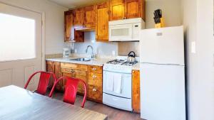 a kitchen with a white refrigerator and a table and chairs at Downtown Cozy Home Base - Purple Sage 7 in Moab