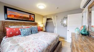a bedroom with a large bed and a table at Downtown Cozy Home Base - Purple Sage 7 in Moab