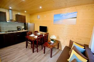 a kitchen and a dining room with a table and chairs at Ośrodek Wypoczynkowy IDA in Mielenko