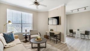 een woonkamer met een bank en een tafel bij Landing Modern Apartment with Amazing Amenities (ID7966X24) in Lewisville