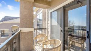 een balkon met 2 stoelen en glazen schuifdeuren bij Landing Modern Apartment with Amazing Amenities (ID7966X24) in Lewisville