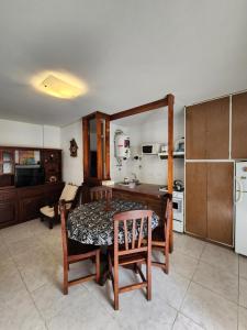 cocina con mesa, sillas y nevera en Departamento Atlántico I en San Bernardo