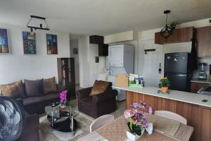 a living room with a couch and a kitchen at Apartamentos de la Rosa -Departamento Nuevo in Cobán
