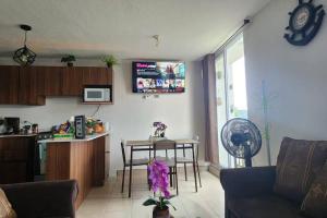 uma sala de estar com uma cozinha e uma mesa com cadeiras em Apartamentos de la Rosa -Departamento Nuevo em Cobán