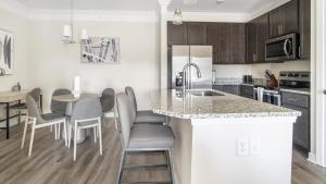 cocina con encimera, mesa y sillas en Landing Modern Apartment with Amazing Amenities (ID1012X166), en Clayton