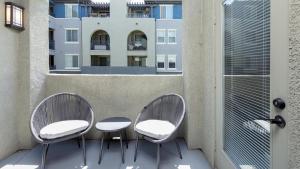 Duas cadeiras e uma mesa numa varanda com um edifício em Landing Modern Apartment with Amazing Amenities (ID5499X01) em San Diego