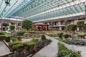 un jardín interior con plantas y árboles en un edificio en Radisson Hotel & Convention Center Toluca, en Toluca