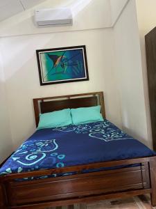a bedroom with a bed with a blue comforter at Secret Paradise in Cocles