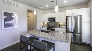 uma cozinha com armários brancos e um balcão de granito em Landing Modern Apartment with Amazing Amenities (ID7635X27) em Littleton