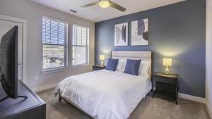 um quarto com uma cama com paredes azuis e uma televisão em Landing Modern Apartment with Amazing Amenities (ID7635X27) em Littleton