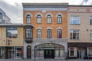 a large brick building with an archway on a street at -NEW- The Rock and Red Luxury Condo in Quebec City