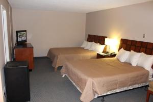 a hotel room with two beds and a television at Travelodge by Wyndham Swift Current in Swift Current