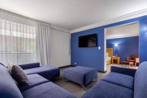 Sala de estar azul con sofá y TV en Radisson Hotel & Convention Center Toluca, en Toluca