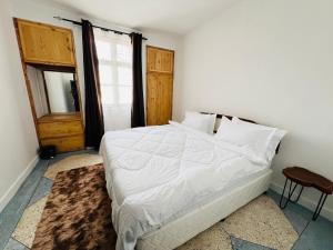 - une chambre avec un grand lit blanc et une fenêtre dans l'établissement Urban Haven -Entire Apartment, à Iringa