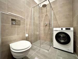 La salle de bains est pourvue de toilettes et d'un lave-linge. dans l'établissement Gellert Danube Panorama Apartment, à Budapest
