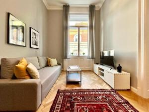 - un salon avec un canapé et une télévision dans l'établissement Gellert Danube Panorama Apartment, à Budapest