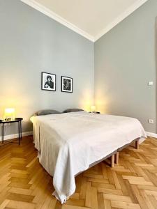 - une chambre blanche avec un grand lit et du parquet dans l'établissement Gellert Danube Panorama Apartment, à Budapest
