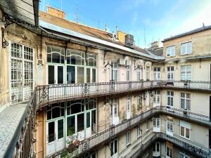 - un ancien bâtiment avec des balcons sur le côté dans l'établissement Gellert Danube Panorama Apartment, à Budapest