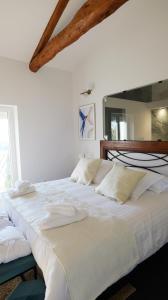 a large white bed with white sheets and pillows at Chambres d'Hôtes Doux Brazil in Lisle-sur-Tarn
