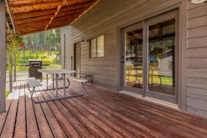 un patio con mesa y sillas en una terraza en Cabin 6 at Horse Creek Resort en Rapid City