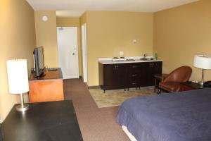um quarto de hotel com uma cama um lavatório e uma televisão em Travelodge by Wyndham Swift Current em Swift Current