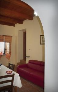 een woonkamer met een rode bank en een tafel bij La Costa Del Sole in San Fele