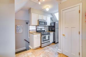 een keuken met witte kasten en een fornuis met oven bij Pet-Friendly Minneapolis Apartment Near Downtown! in Minneapolis