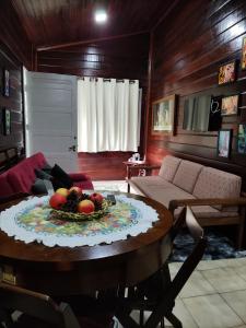 ein Zimmer mit einem Tisch und einer Obstschale darauf in der Unterkunft Chalé Manacá House in Campos do Jordão