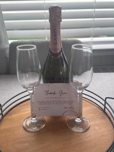 two wine glasses on a table with a bottle of wine at Seton sands holiday village in Port Seton