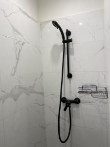 a shower with a black shower head in a bathroom at Casa Csokonai in Budapest