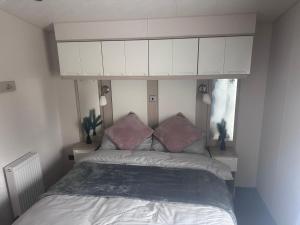 a bedroom with a bed with a white cabinet above it at Seton sands holiday village in Port Seton
